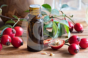 A bottle of rose hip seed oil on a wooden table