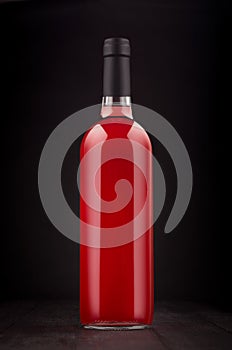 Bottle of rose wine mock up on elegant dark black wooden background, vertical.