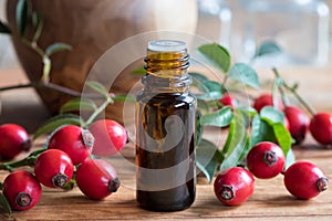 A bottle of rosehip seed oil on a wooden table photo