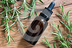 A bottle of rosemary essential oil with rosemary twigs