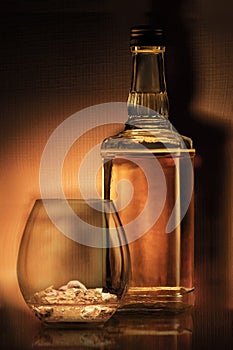 a bottle of rum , golden whiskey or liqueur . a glass of bourbon has a beautiful dark background. elite alcoholic retro