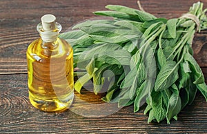 Bottle of sage oil and sage leaves