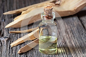 A bottle of sandalwood essential oil with white sandalwood photo