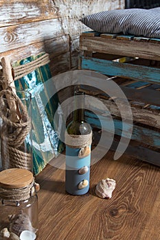 Bottle with shells, anchor painting, sea theme on wooden background