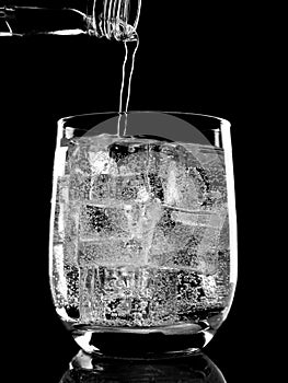 Bottle of soda mineral water pouring into glass