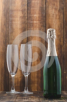 Bottle of sparkling wine and two glasses on a wooden background. Clebration background