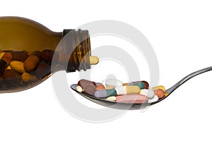 Bottle And Spoon With Pills Tabletts On White