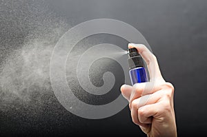 Bottle spraying against gray background