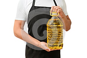 A bottle of sunflower oil in the hands of a cook isolated on a white background