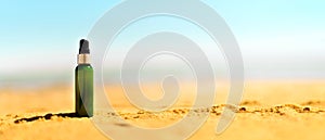 Bottle of sunscreen in sand against sea background with copyspace. Vacation and travel wallpaper. Skin care concept