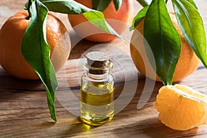 A bottle of tangerine essential oil on a wooden background