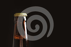 Bottle of tasty cold beer on black background