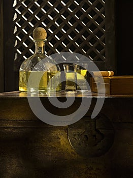 bottle of tequila anejo and glasses on color background
