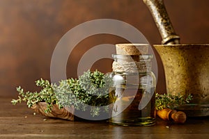 Bottle of thyme essential oil with fresh thyme