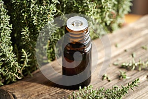 A bottle of thyme essential oil with fresh thyme leaves