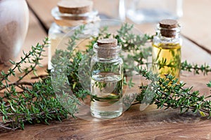 A bottle of thyme essential oil with fresh thyme twigs