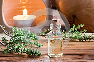 A bottle of thyme essential oil with fresh thyme twigs