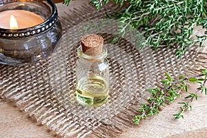 A bottle of thyme essential oil with fresh thyme twigs