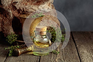 Bottle of thyme essential oil with fresh thyme twigs