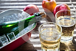 Bottle and two glasses of cider on the wooden background