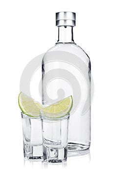 Bottle of vodka and shot glasses with lime slice
