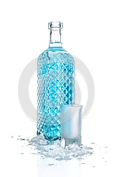 Bottle of vodka with wineglass and ice