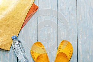 Bottle of water and bright towels, yellow shale on blue background.