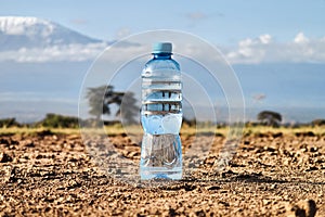 A bottle of water on dried ground. The concept of thirst, dehydration. problem of global warming and drought in Africa.