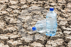 Bottle with water on the dried ground.