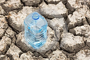 Bottle with water on the dried ground.