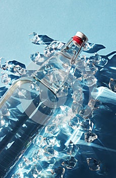 Bottle of water with ice on a blue