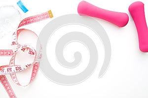 Bottle of water, measuring tape and dumbbells on white background, Diet and Fitness concept