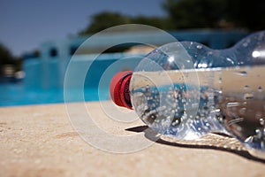 Una botella de Agua sobre el al lado de la piscina 