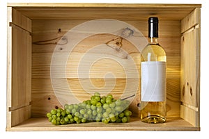 A bottle of white wine and grapes in a wooden box  with copy space