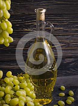 Bottle of white wine, sommelier vintage   celebration grapes on wooden background