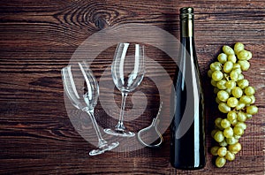 Bottle of white wine, two glasses and grapes