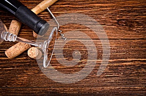 Bottle of wine, corkscrew and corks on wooden table. Background