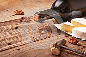 Bottle wine with corkscrew. with grapes, slice cheese camembert, nut on old gray concrete table background with copy space. Red