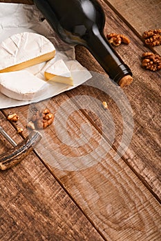 Bottle wine with corkscrew. with grapes, slice cheese camembert, nut on old gray concrete table background with copy space. Red