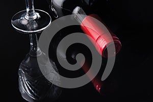 Bottle of wine and a glass on a black background