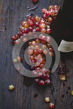 Bottle of wine and grape on wooden background