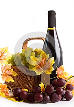 Bottle of wine with grapes in basket