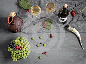 A bottle of wine, grapes and wine in a jug and glasses