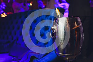 Bottle of wine in ice bucket on darck purple background.