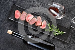 Bottle of wine with sliced filet mignon photo