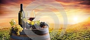 Bottle And WineGlasses On Barrel In Vineyard photo