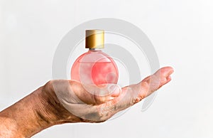 bottle of women's perfume in a man's hand