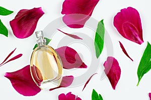 Bottle of women`s perfume on a white background with pink petals and green leaves