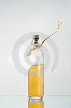 Bottle with yellow liquid and empty label on the light backgroun