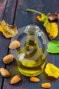 Bottled almond oil with almonds around photo